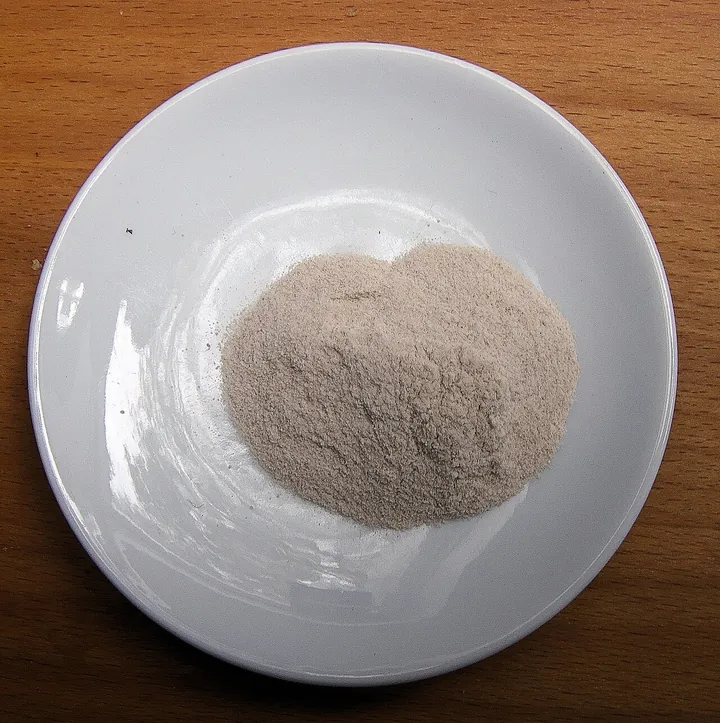 A close-up of psyllium seed husks — small pearlescent flakes